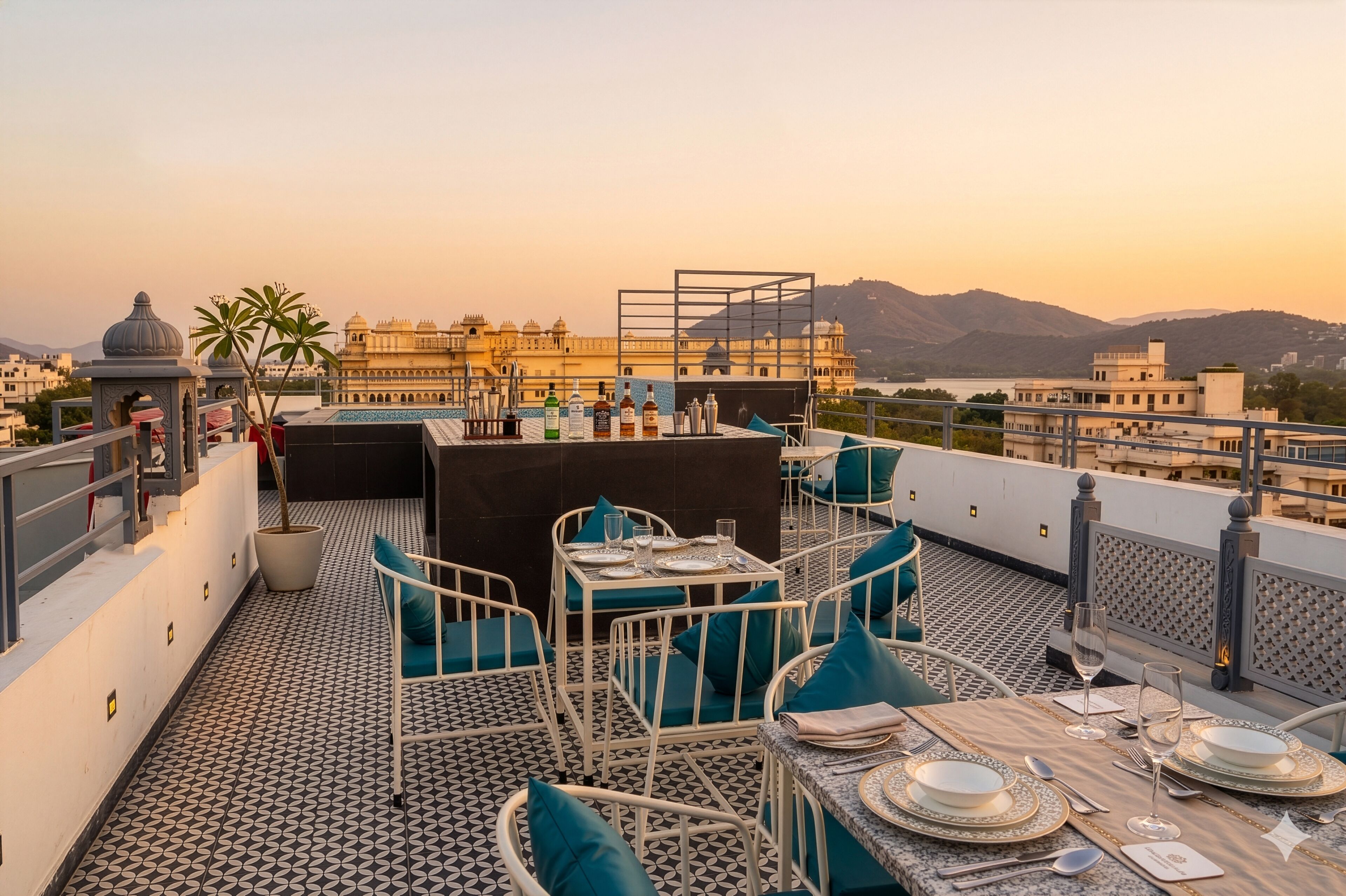 Une terrasse sur le toit, avec des tables dressées pour le dîner, une vue sur un palais et un paysage montagneux en arrière-plan.