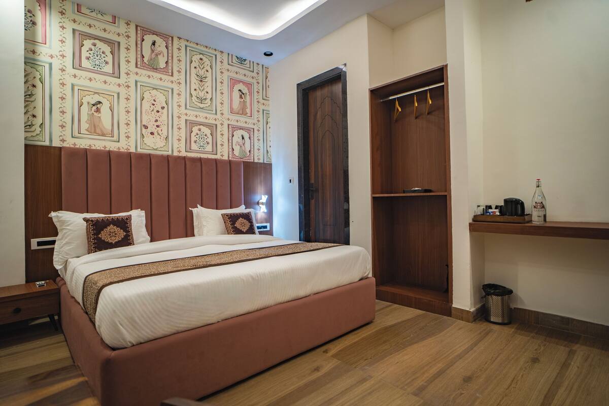 Un dormitorio con una cama grande, un armario, una mesita de noche y una pared con paneles decorativos.