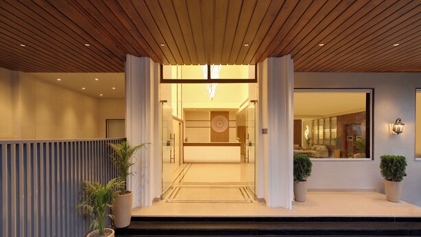 A modern hotel entrance with a wooden ceiling, a reception desk, and potted plants. - Keys Select by Lemon Tree Hotel Amritsar (Amritsar)