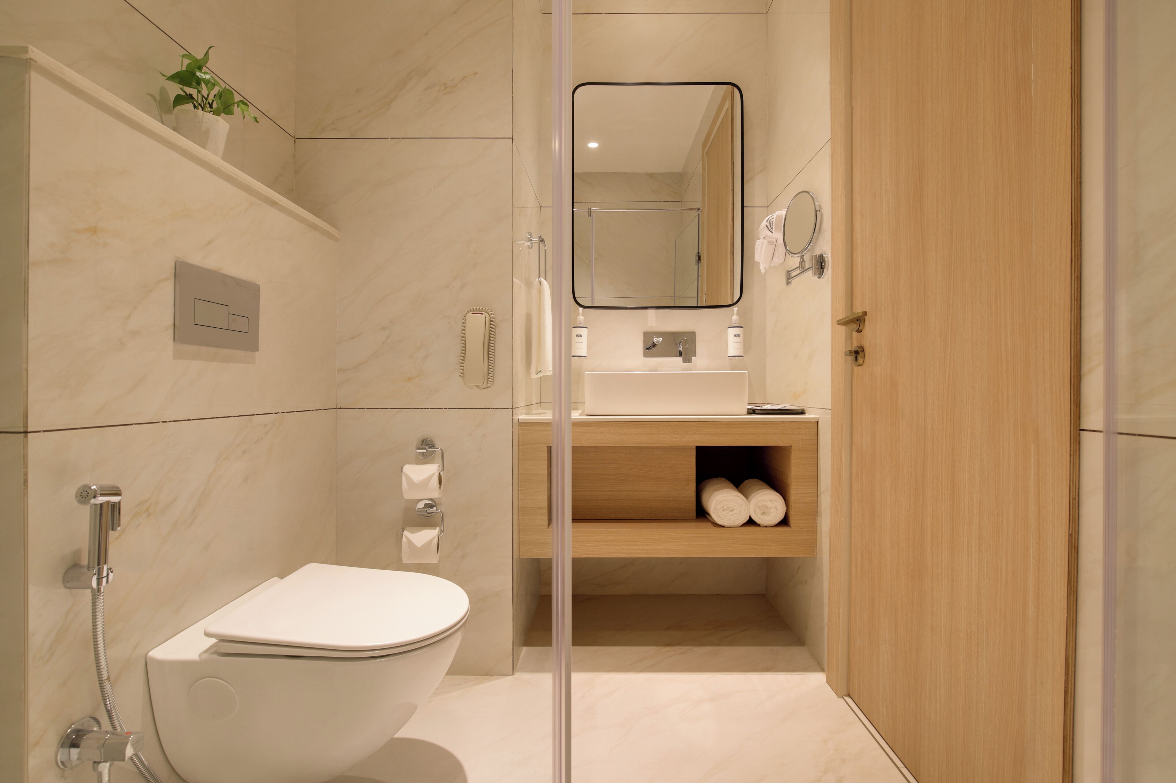 A modern bathroom with a toilet, shower, and sink.