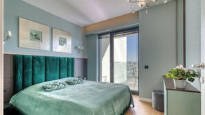 Een slaapkamer met een bed, een balkon en uitzicht op de stad.