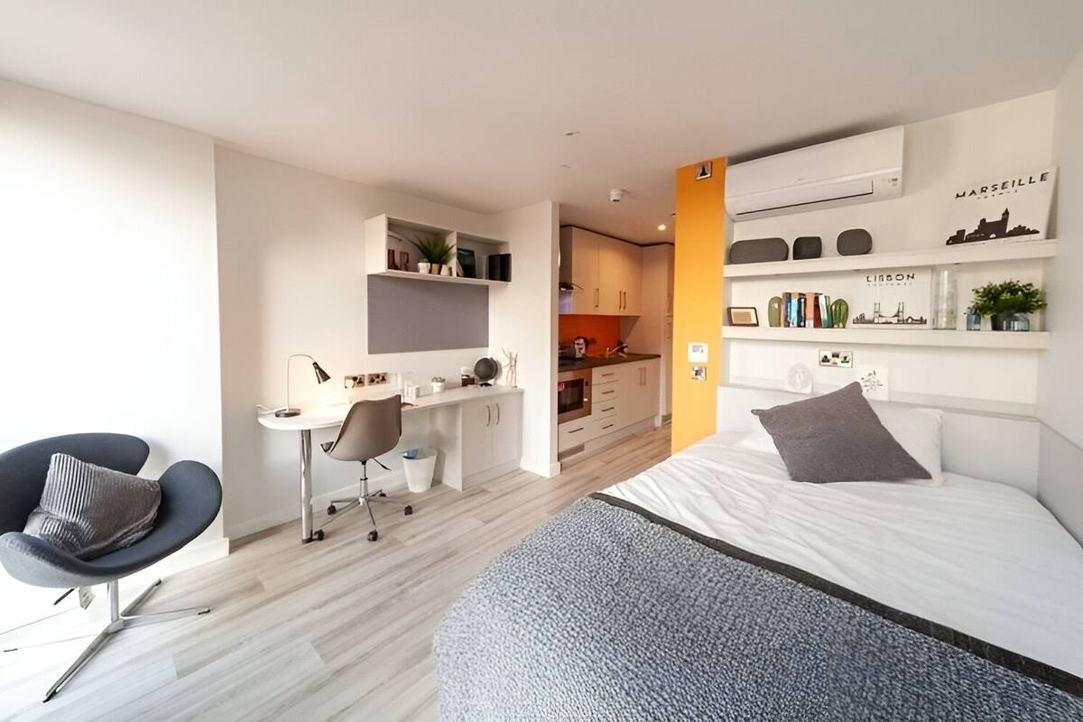 A modern bedroom with a bed, a desk, and a chair.