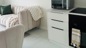 A modern kitchen with a microwave, a white cabinet, and a black oven. - Zerilith Haven self catering (Swakopmund)
