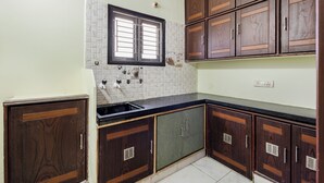 Eine Küche mit Holzausstattung, einem Fenster und einer Fliesenküchenwand.