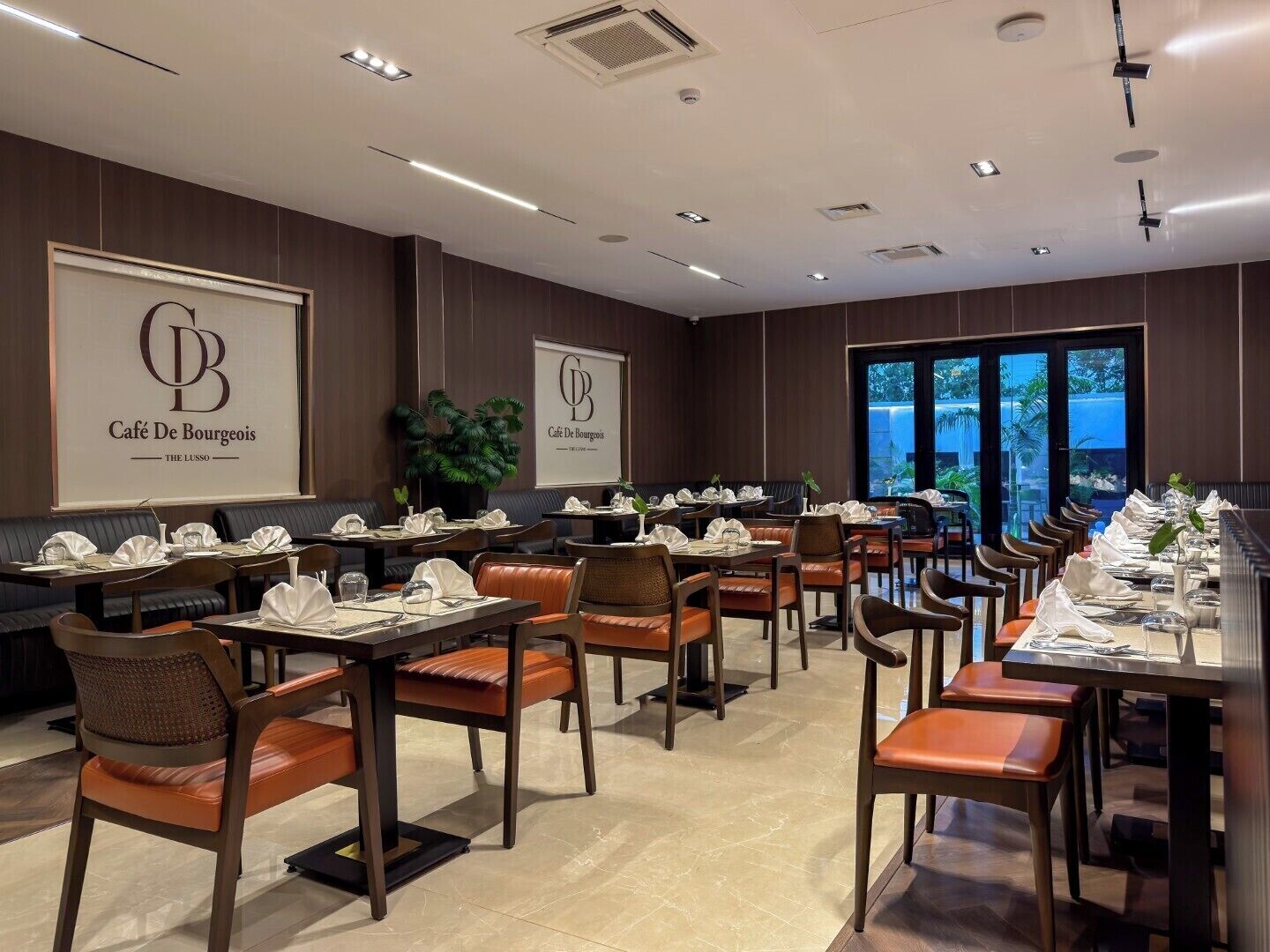 Un restaurant doté d’un long comptoir, de plusieurs tables et de chaises.