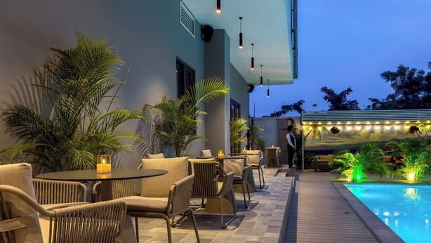 A poolside area with outdoor seating and a view of the pool.