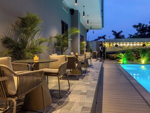 A poolside area with outdoor seating and a view of the pool. - The Lusso Hotel (Abuja)
