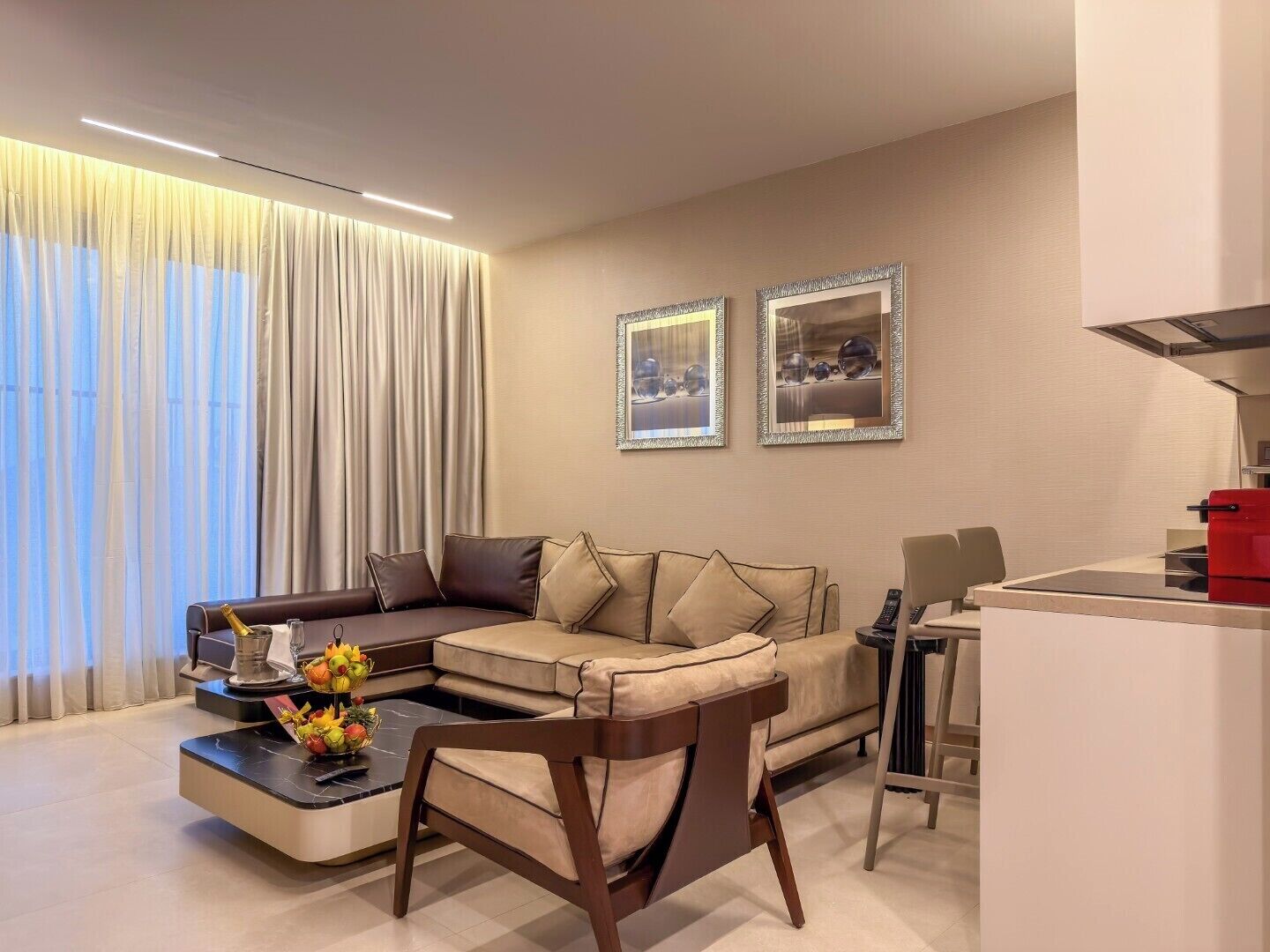 Een moderne woonkamer met een modulaire bank, een salontafel, een eethoek en twee ingelijste foto's aan de muur.