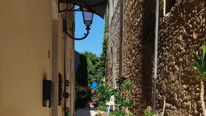 A narrow stone-paved alleyway with a bench, potted plants, and a lamp post. - House with hot tub ( BRAMA WELLNESS EXPERIENCE) (Brindisi)