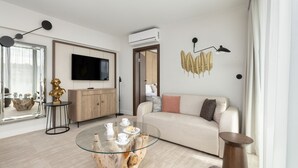 A modern living room with a sofa, a glass coffee table, a TV, and a wooden cabinet. - Bluewave - Wave Resort & Spa (Międzyzdroje)