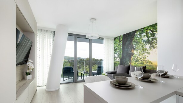 A modern dining area with a large window, a dining table set with plates and glasses, and a view of greenery outside. - Nubo - Wave Resort & Spa (Międzyzdroje)