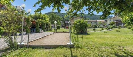 A courtyard with a pergola, outdoor seating, and a view of a mountain.