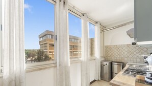A kitchen with a window, a stove, and a dishwasher. - Home Karalis Apartment (Su Planu)