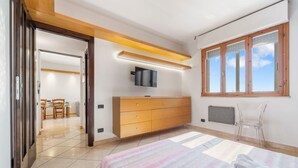 A bedroom with a bed, a dresser, a TV, and a window. - Home Karalis Apartment (Su Planu)