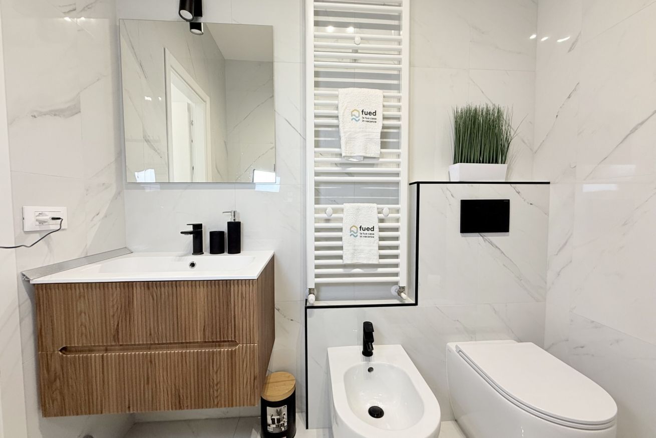 Un bagno moderno con un vanità in marmo, bidet e servizi igienici.