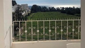 A balcony with a metal railing, a clear sky, and a distant view of buildings and greenery. - Peaceful haven by the sea, a stone's throw from the town center 🌊 (Hammamet)