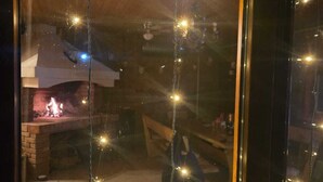 Une pièce avec une cheminée, un canapé et des guirlandes lumineuses.