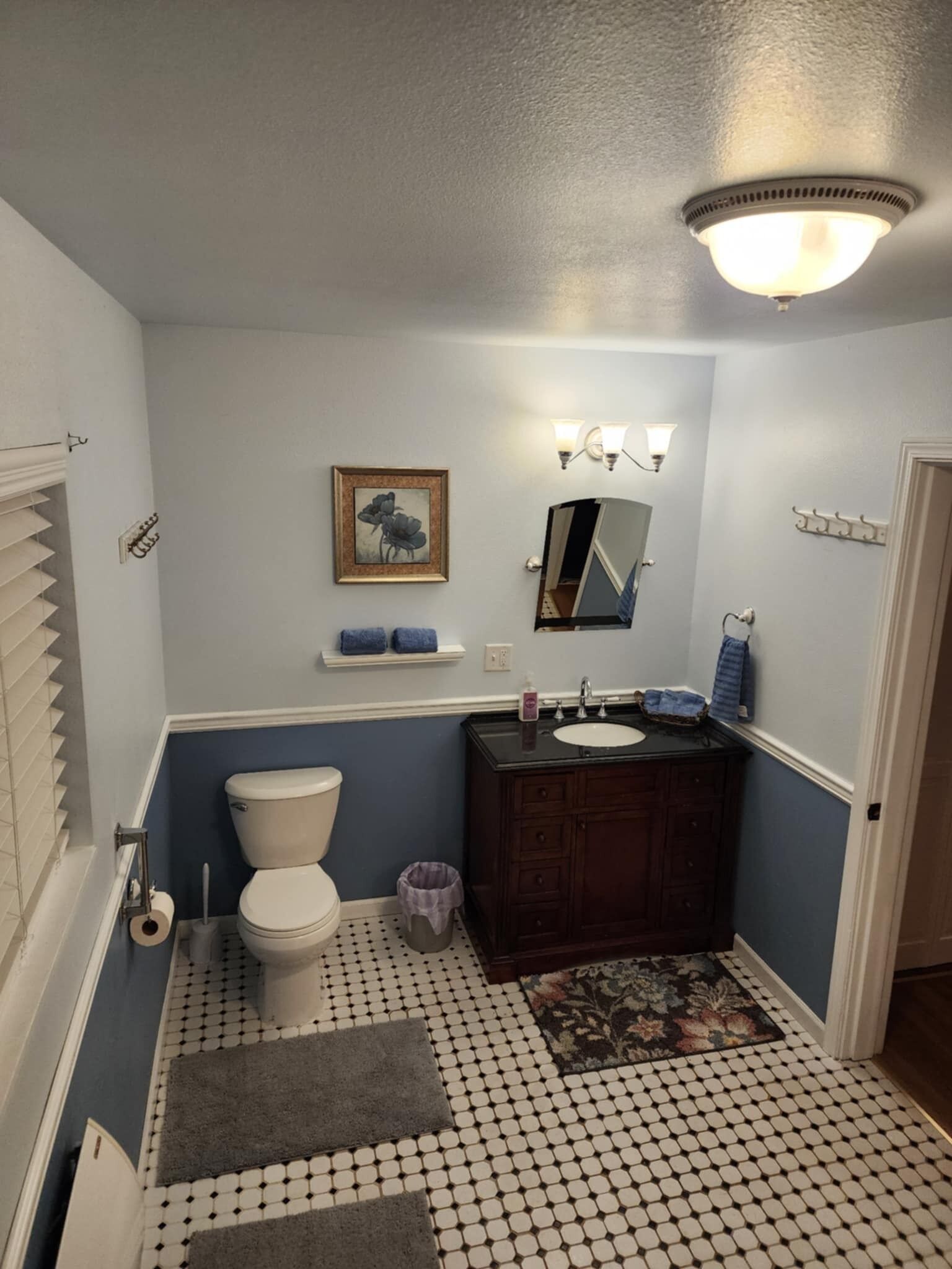 Een badkamer met toilet, wastafel, badkamermeubel en spiegel.