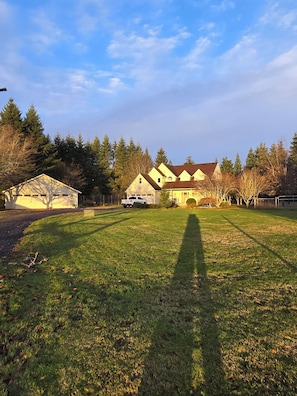 A residential property with a large lawn, a garage, and a detached garage.