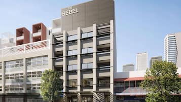 A multi-story hotel with a modern design, featuring balconies, large windows, and a prominent signage.