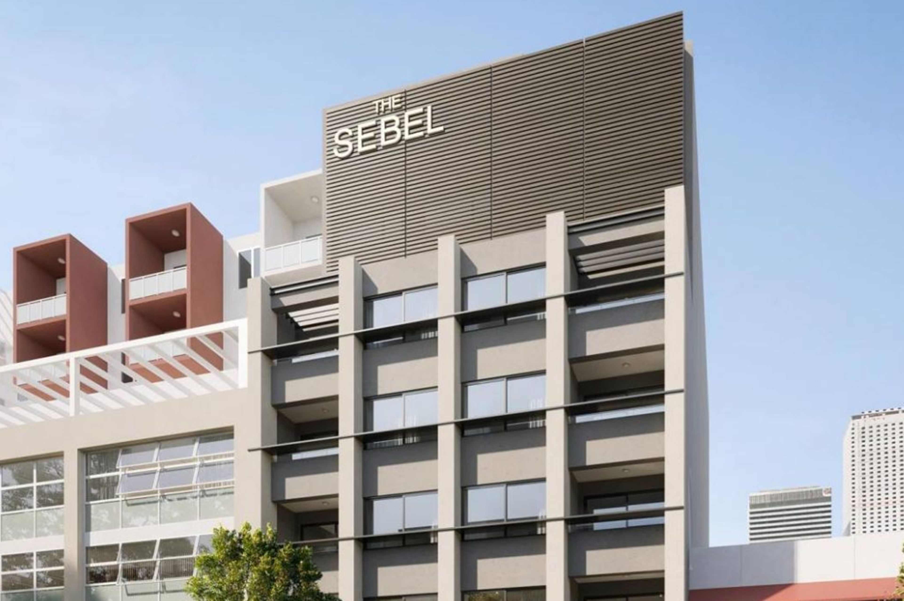 Un bâtiment moderne dont la façade est ornée d’une enseigne bien visible portant l’inscription « THE SEBEL ».