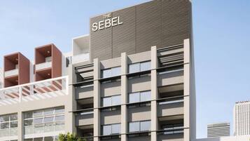 A modern building with a prominent sign reading 'THE SEBEL' on the facade.
