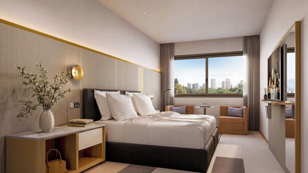 Een moderne hotelkamer met een groot bed, nachtkastjes, een bureau, een stoel, een televisie en een raam met uitzicht op de stad.
