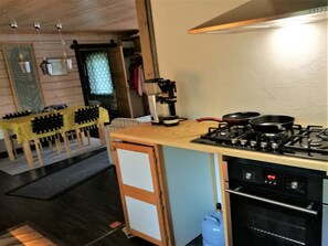 A compact kitchen with a gas stove, oven, and a small refrigerator.