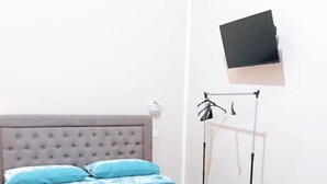 A bed with a tufted headboard, a teal bedspread, and two pillows. - Antonella's Suites (Taranto)