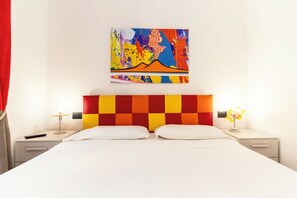 A hotel room with a large bed, two bedside tables, a colorful abstract painting on the wall, and a red curtain. - Casa di Rosy (Naples)