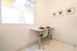 A dining area with a table, chairs, and framed pictures on the wall. - L'Aurora Apartments (Naples)