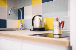 A kitchen with a kettle, a faucet, and a small container with utensils. - L'Aurora Apartments (Naples)