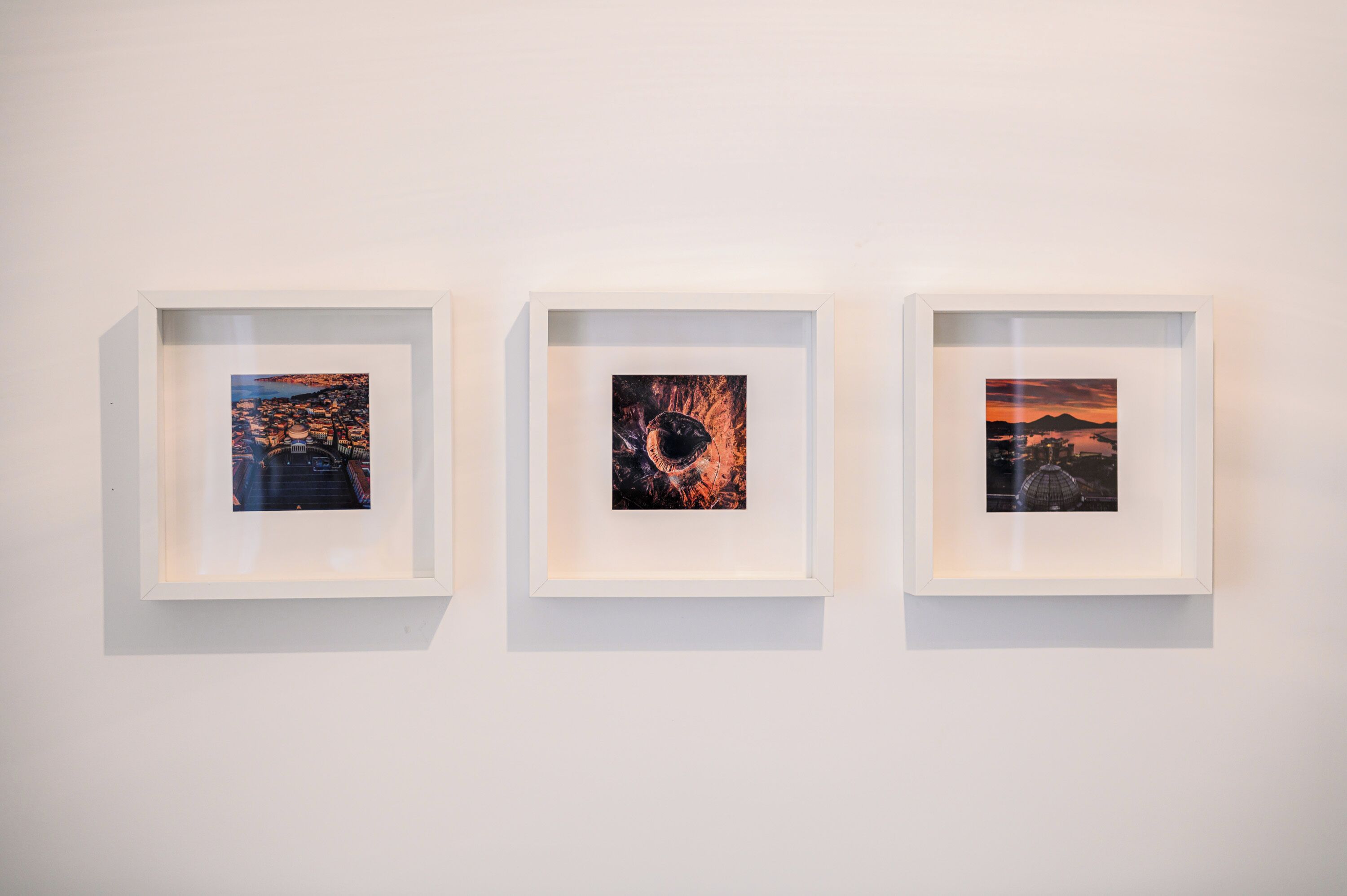 Three framed artworks on a white wall.