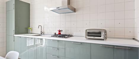 Una cocina moderna con estufa a gas, tostadora y pileta.