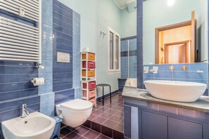 A bathroom with a white sink, a toilet, and a bidet. There is a mirror above the sink and a towel rack on the wall. - Il Gazebo a Monteverde (Rome)