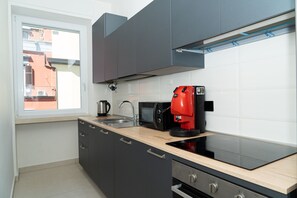 A modern kitchen with a built-in oven, a coffee machine, and a microwave. - Via Niccolò Tommaseo 4 - Appartamento 1 (Naples)
