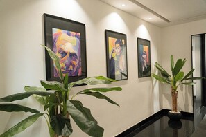 A hallway with three framed artworks on the wall and two potted plants. - Via Niccolò Tommaseo 4 - Appartamento 3 (Naples)