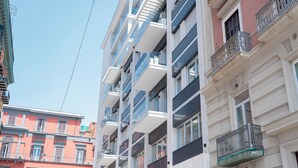 Un edificio a più piani con balconi, ampie finestre e cielo sereno.