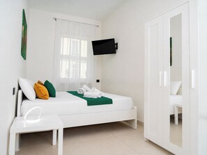 A modern hotel room with a single bed, a bedside table, a flat-screen TV mounted on the wall, and a wardrobe with a mirror. - Via Niccolò Tommaseo 4 - Appartamento 3 (Naples)