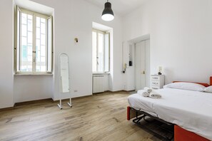 A bedroom with a bed, a wardrobe, a mirror, and a radiator. - Via Morghen 63 - Primo Piano (Naples)