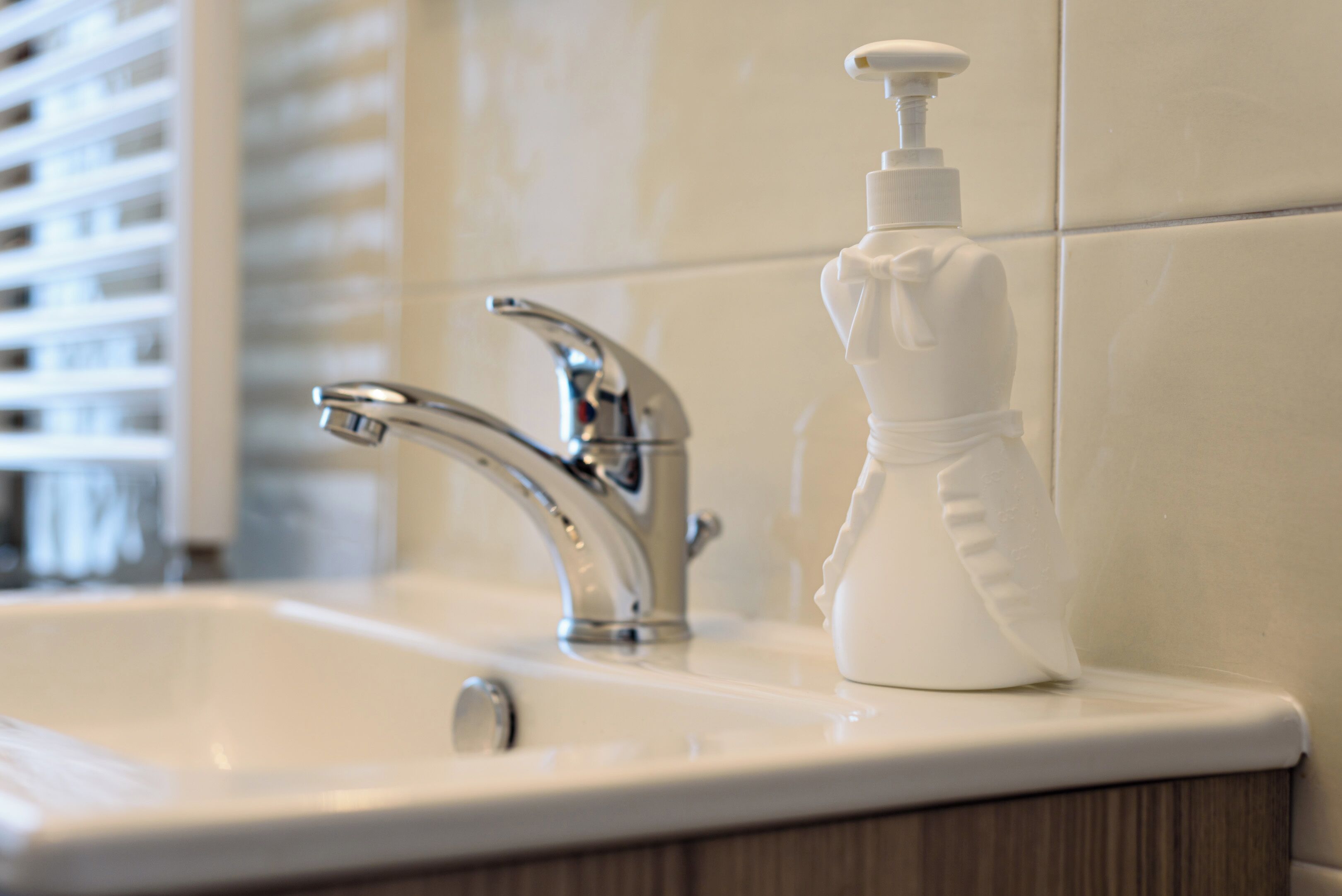 A bathroom sink with a modern faucet and a soap dispenser.