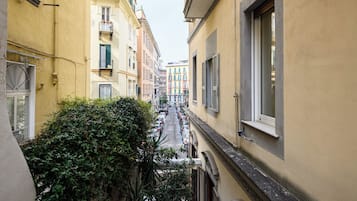 Un vicolo stretto con edifici su entrambi i lati, caratterizzato da balconi e finestre.