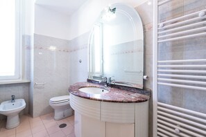 A bathroom with a sink, toilet, bidet, and a towel rack. - Casa Emme (Rome)