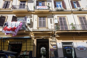 A building facade with multiple balconies, a visible entrance, and signs for 'Casa Cairol' and 'Ortaggi'. - Via Cairoli 60 (Naples)