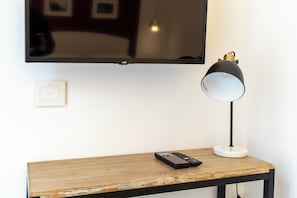 Ein Holztisch mit Fernbedienung und Lampe.