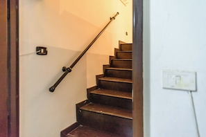 A staircase with a handrail and a light switch on the wall. - Via Duomo 196 (Naples)