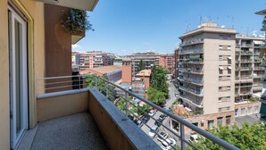 A balcony with a view of a cityscape, including multi-story buildings and parked cars. - Casa Tripolitania (Rome)