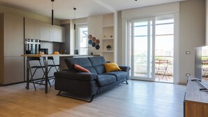 Un espacio habitable moderno con cocina, sofá y comedor.
