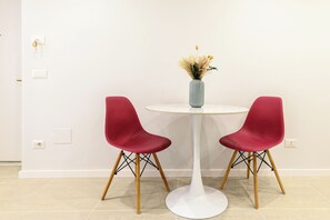 A round white table with two red chairs and a vase with dried flowers. - La Stanza del Principe (Naples)