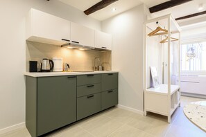 A modern kitchen with a built-in stove, a coffee maker, and a hanging rack. - La Stanza del Principe (Naples)